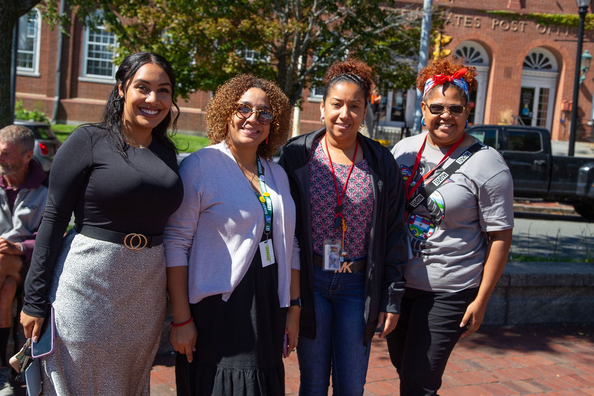 Four young latina woman smile for the camera during the Latinx heritage flag raising in Salem