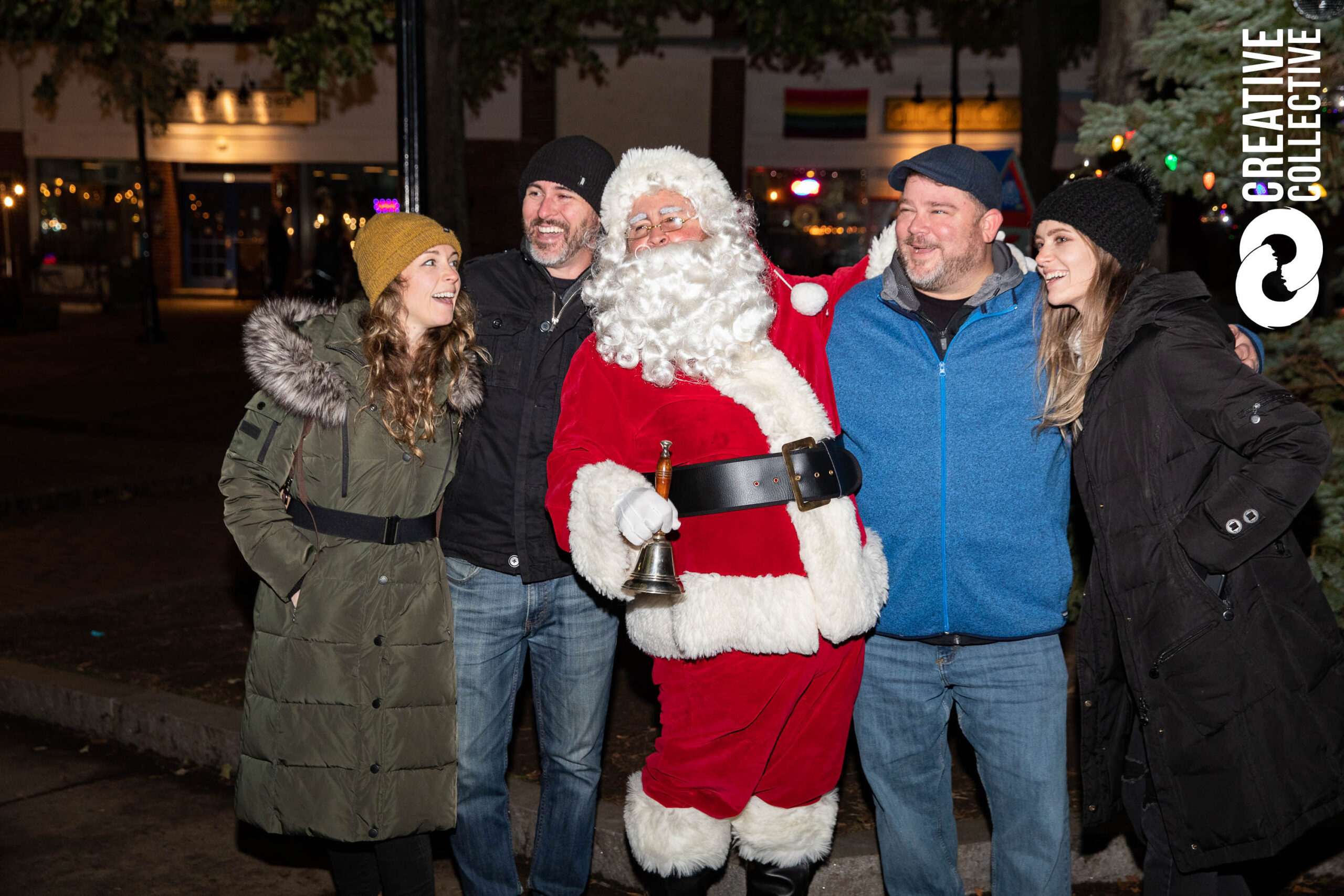 a group of people standing around a santa clause.