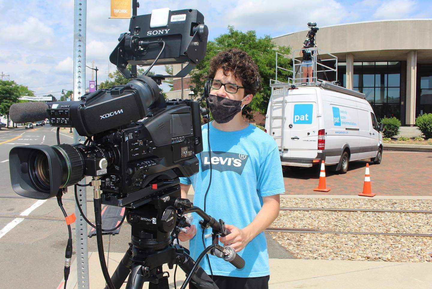 a man wearing a face mask standing in front of a camera.