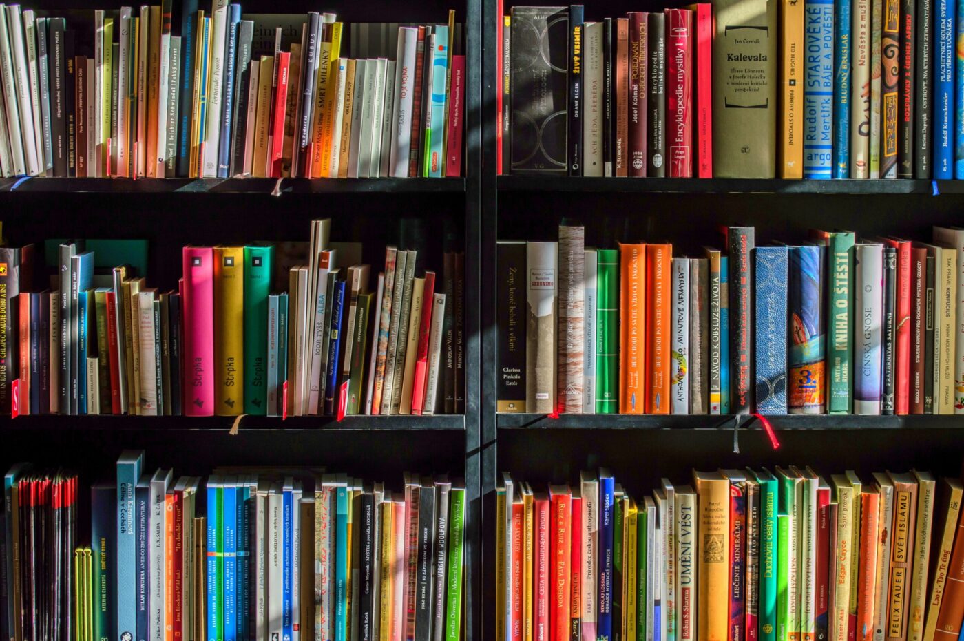 a bookshelf filled with lots of different colored books.