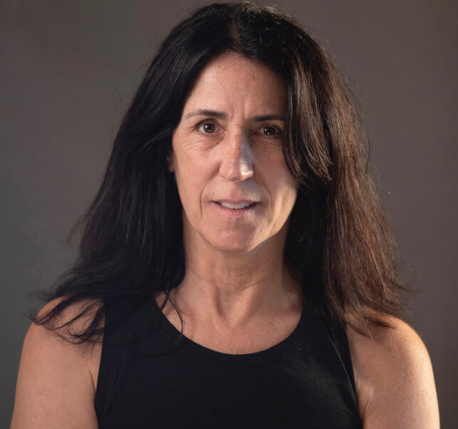 a woman with long hair and a black tank top.