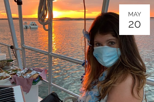 a woman wearing a face mask on a boat.