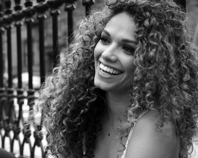 a black and white photo of a woman with curly hair.