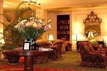 a hotel lobby with chairs, tables, and a vase of flowers.