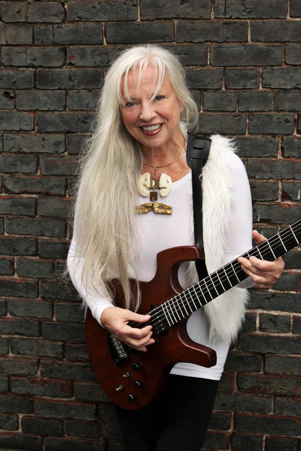 a woman with long white hair holding a guitar.