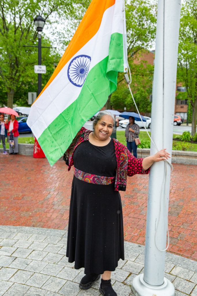 a woman standing next to a flag pole.