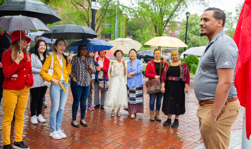 a group of people standing around each other holding umbrellas.