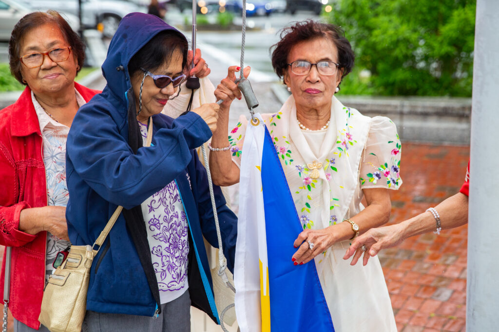a group of women standing next to each other under an umbrella.