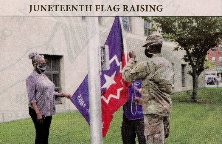 a couple of people standing next to a flag.