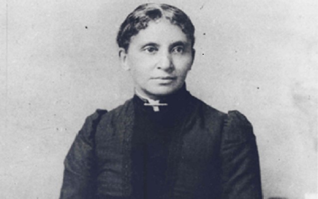 a black and white photo of a woman with a cross on her neck.