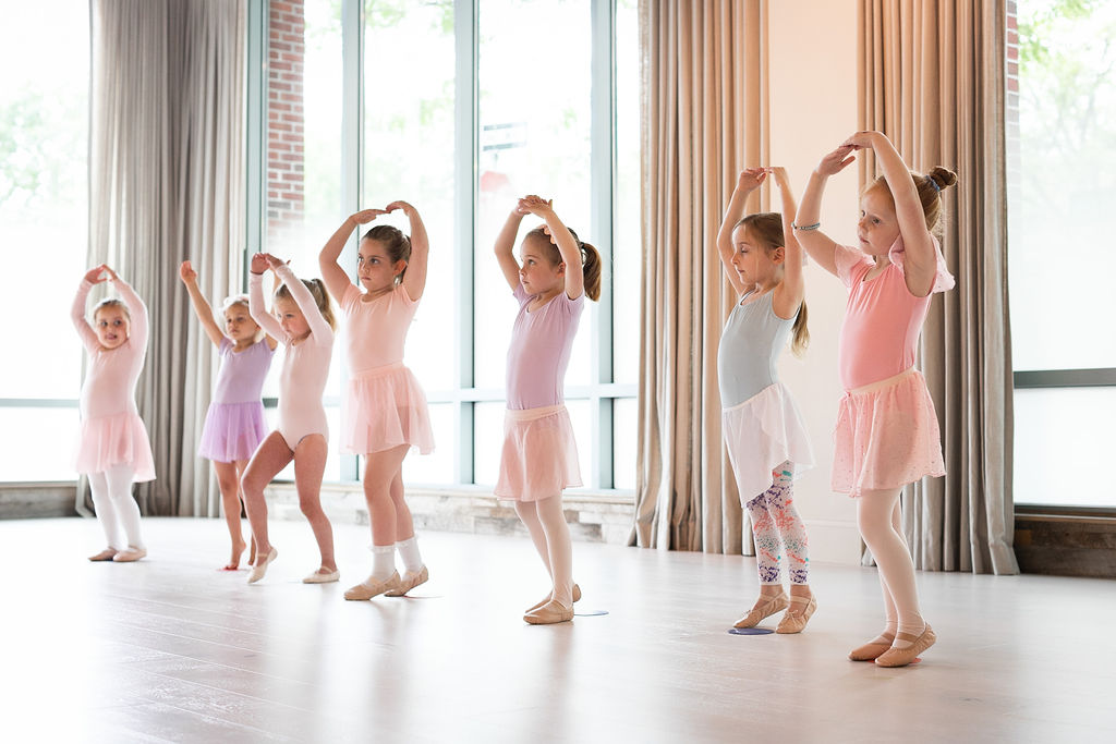 a group of young dancers in a ballet class.
