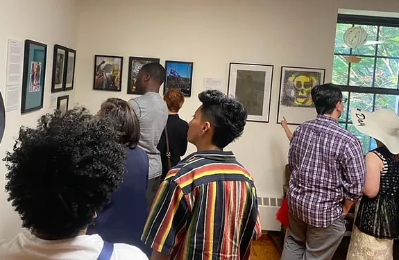 a group of people looking at pictures on a wall.
