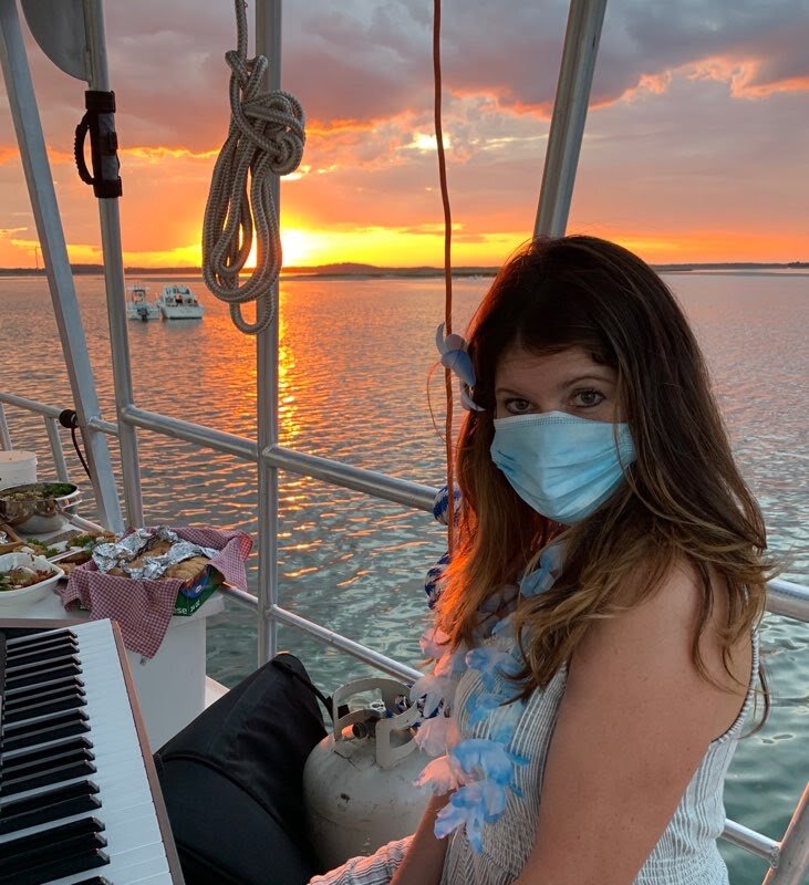a woman wearing a face mask playing the piano on a boat.