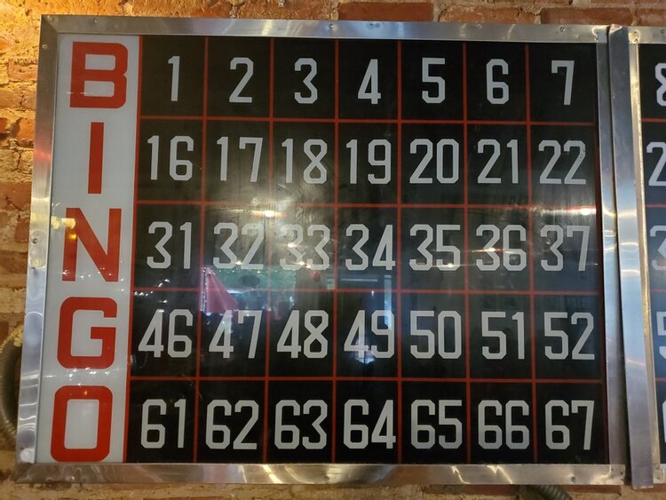 a bingo board with numbers on it in a brick wall.