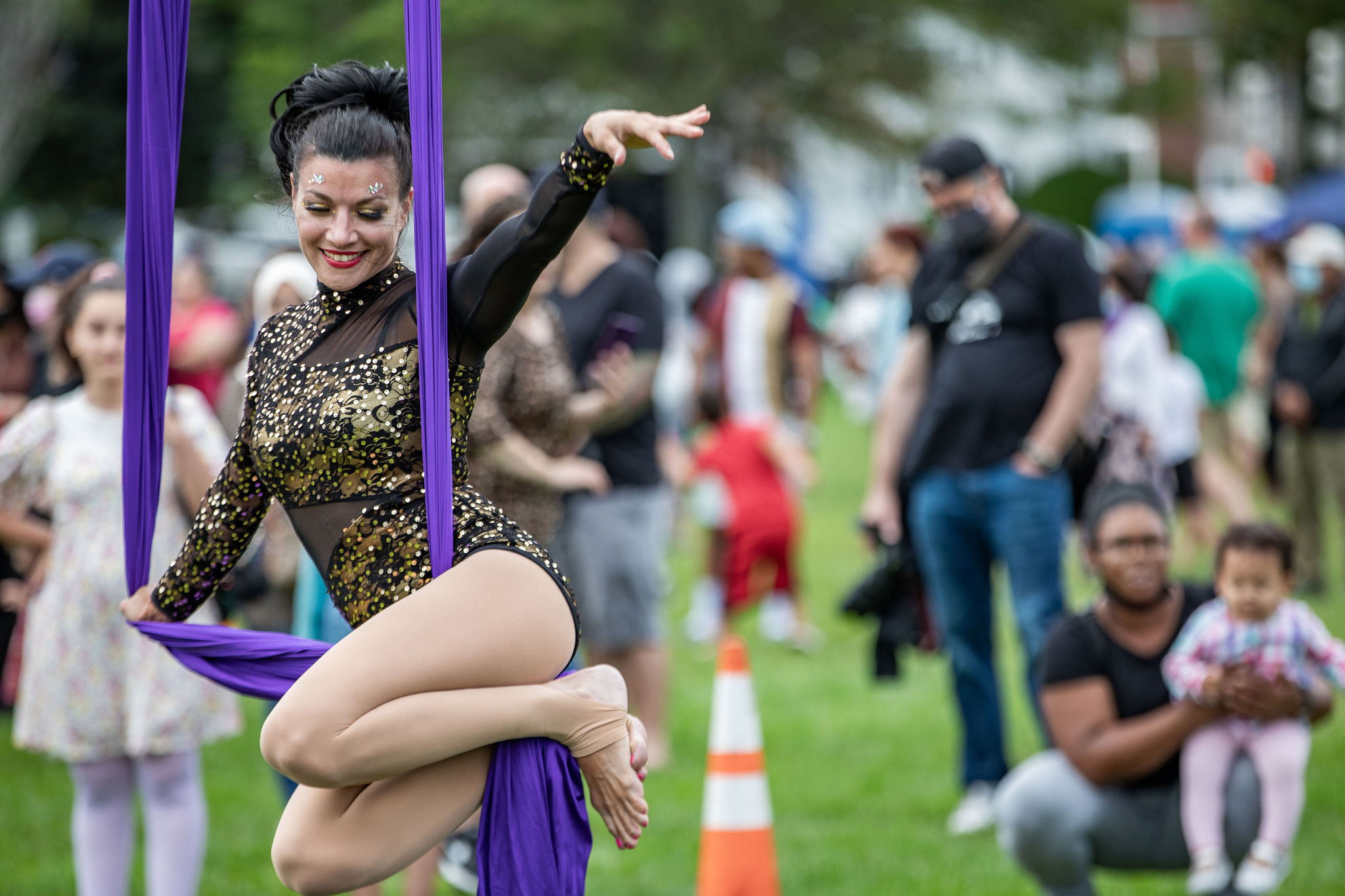 A woman performs acrobatics at a festival.