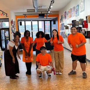 A group of people in orange shirts posing for a picture.