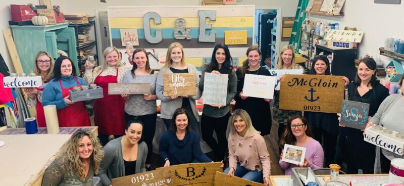 A group of women holding signs in a workshop.