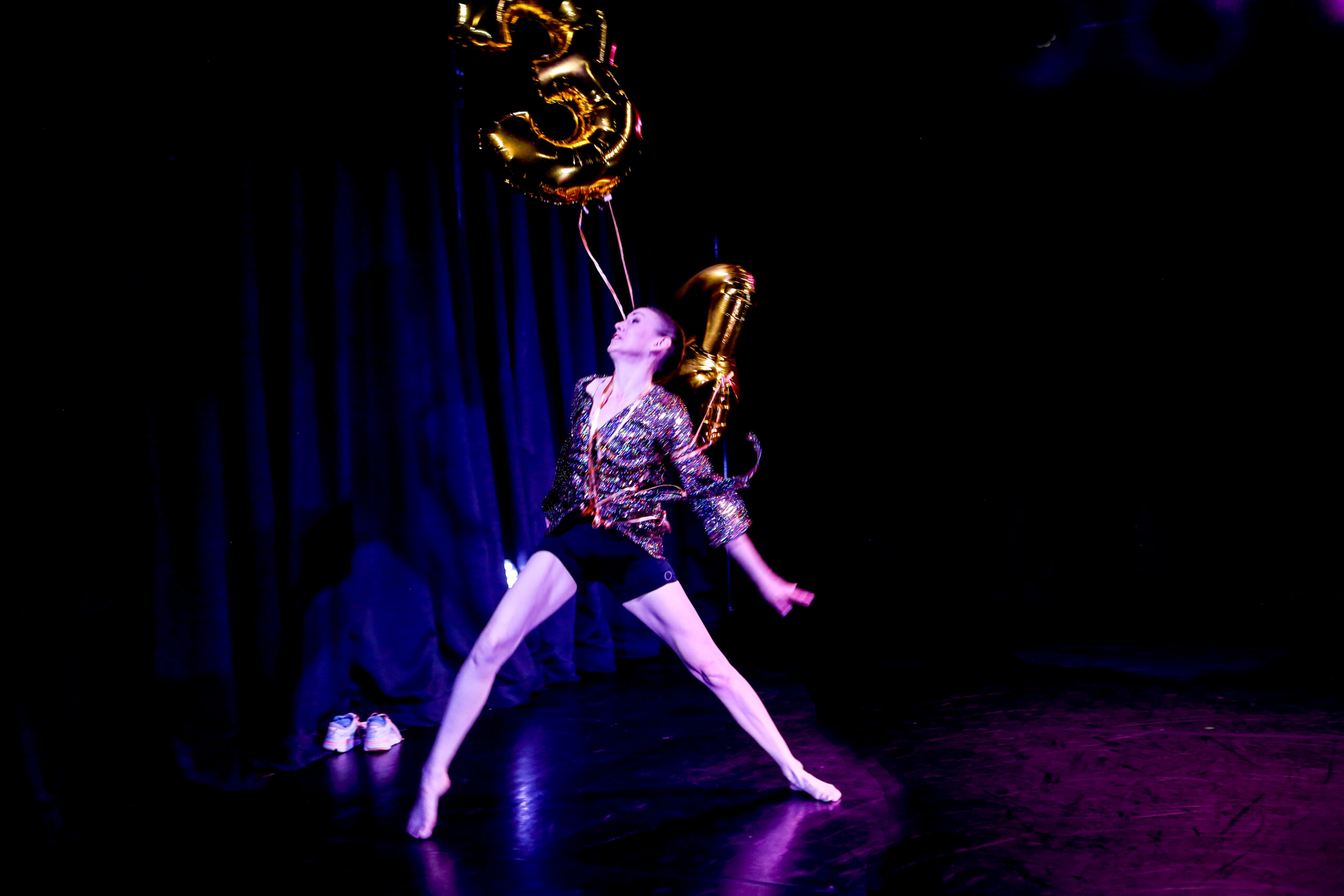 A dancer holding a balloon on stage.