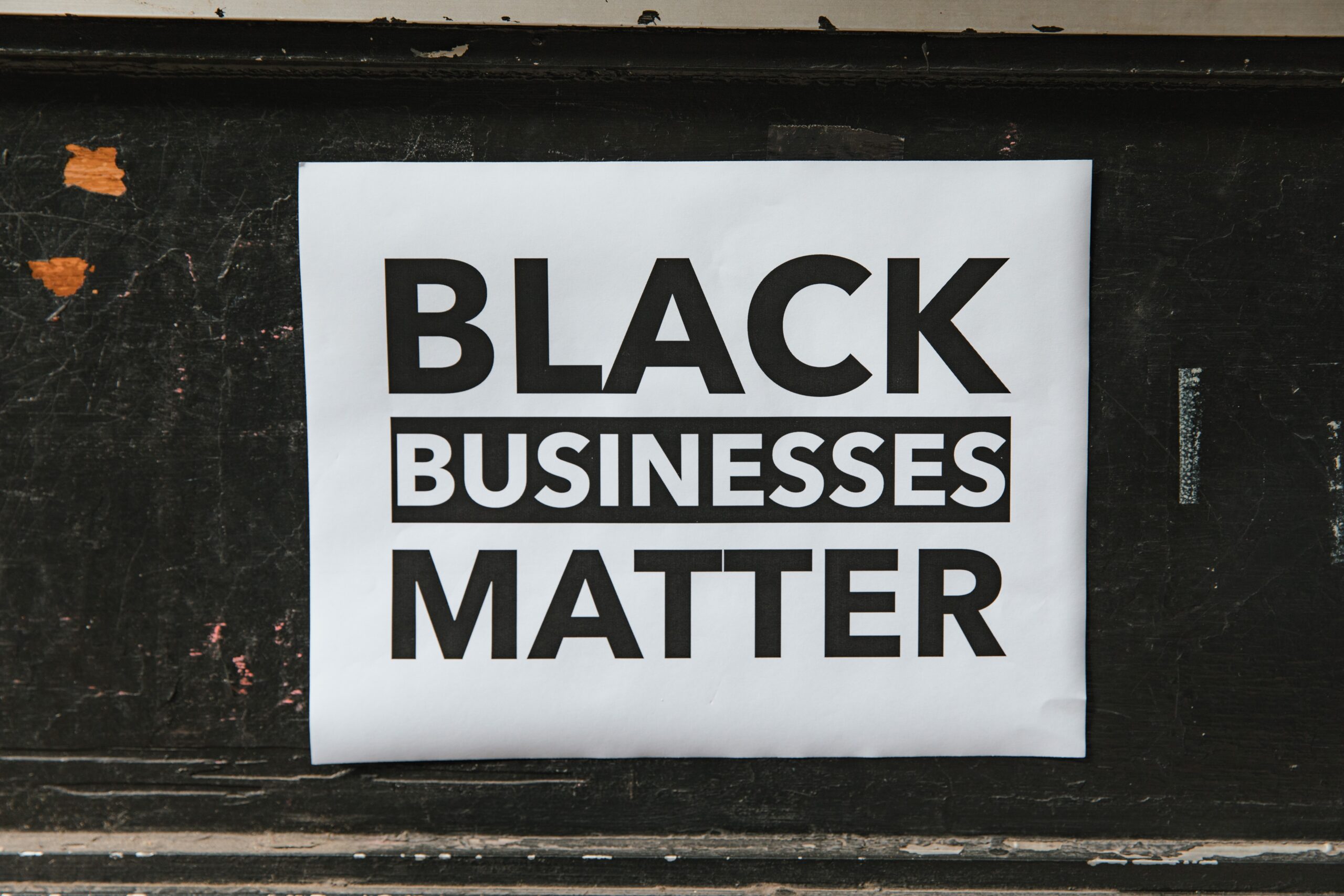 A door adorned with a sign celebrating Black-owned businesses in honor of Black-Owned Business Month.