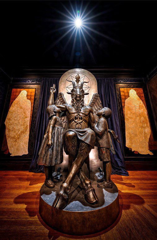 A statue of a demon seated on a throne.