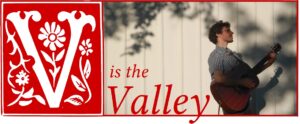 The v is the valley logo with a man holding an acoustic guitar.