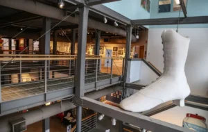A sculpture of a white shoe in a museum.