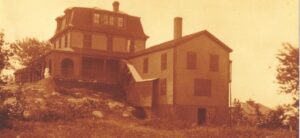 An old photo of a house on top of a hill.