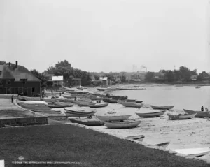 A black and white photo of boats docked on the shore.