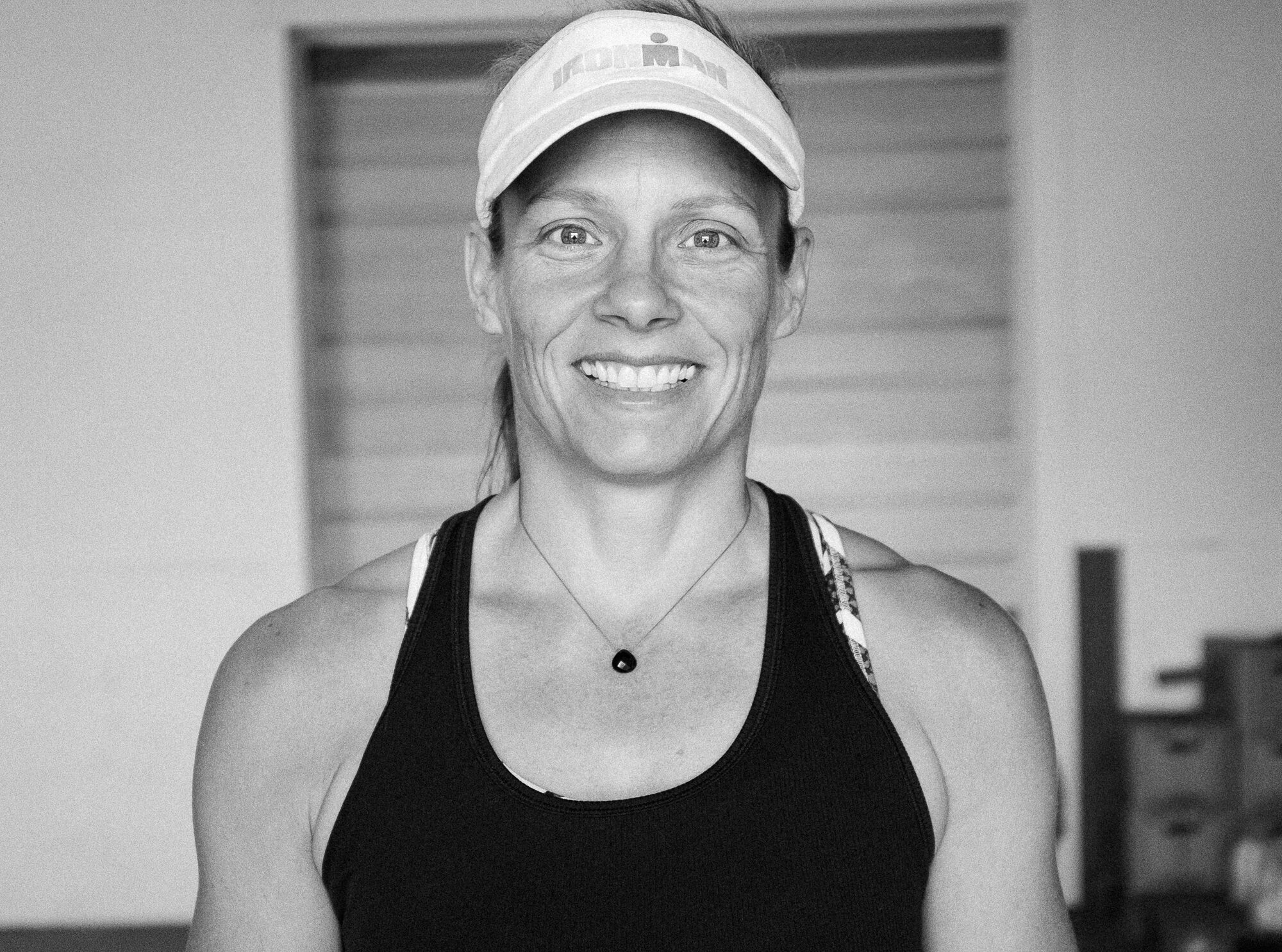 A black and white photo of a woman in a tank top.
