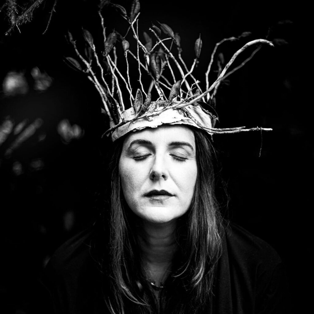 A woman wearing a crown of twigs in a black and white photo, capturing the essence of Small Business Saturday.