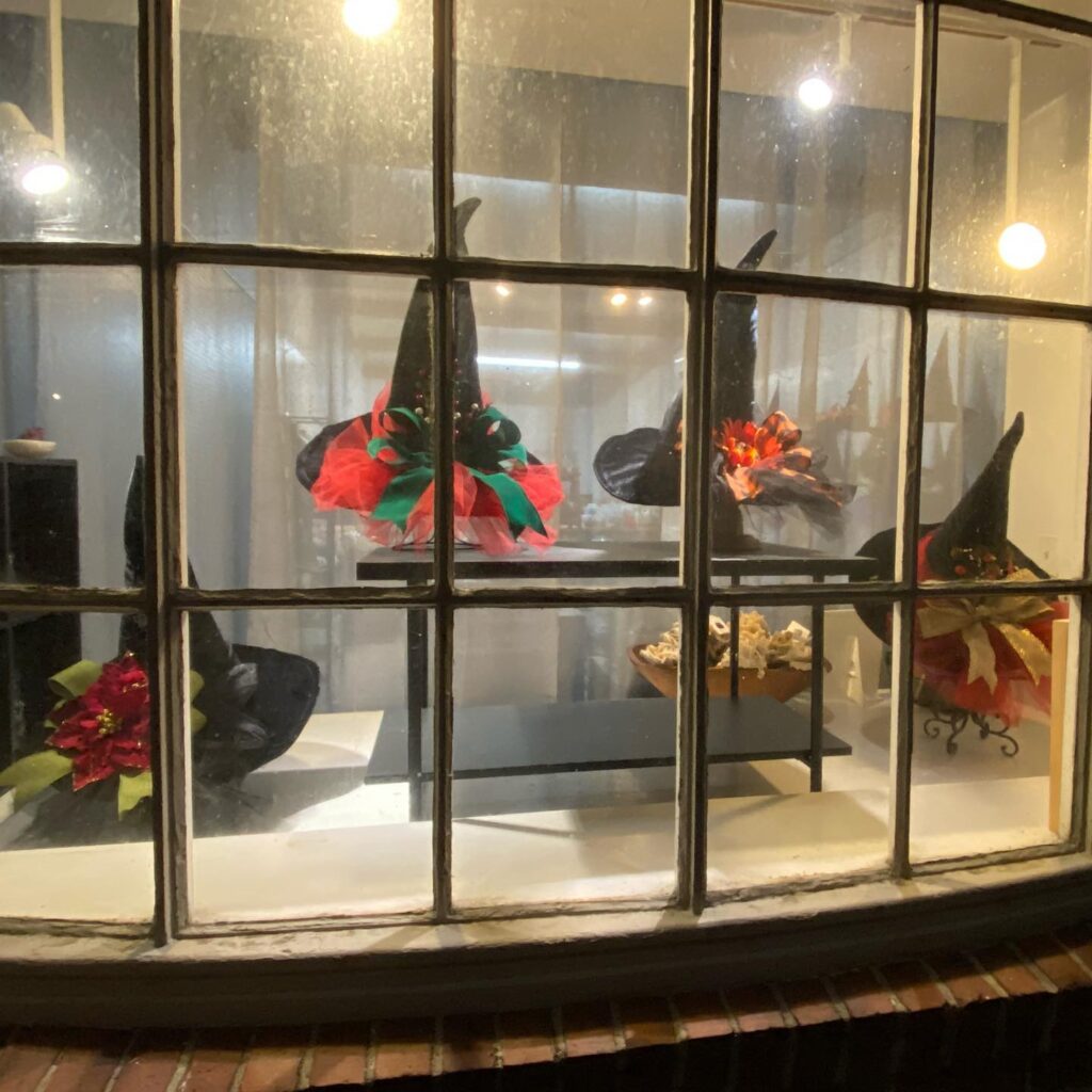 Small Business Saturday display featuring witch hats in a window.
