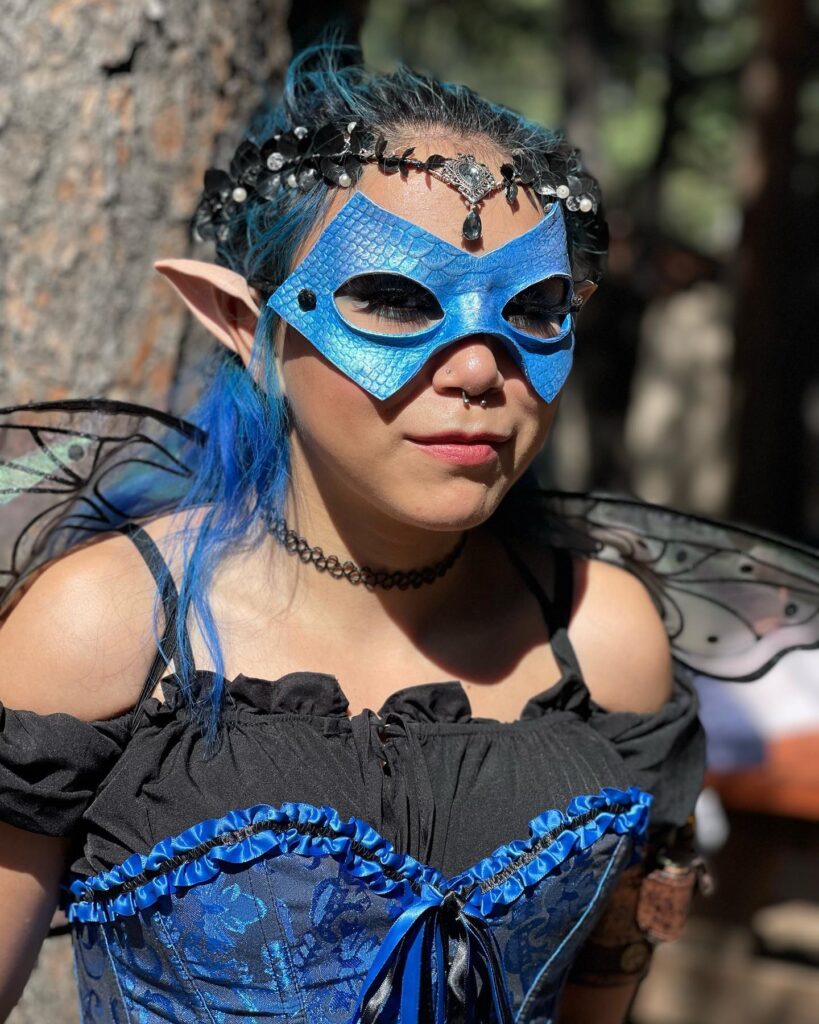 A woman dressed as an elf wearing a blue mask participates in Small Business Saturday.