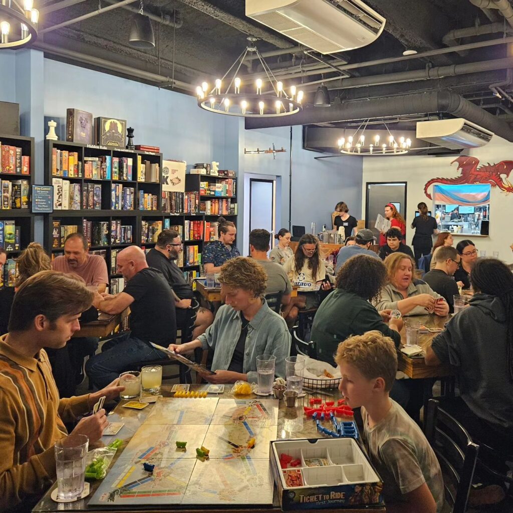 A group of people gathering in a library to play board games on Small Business Saturday.