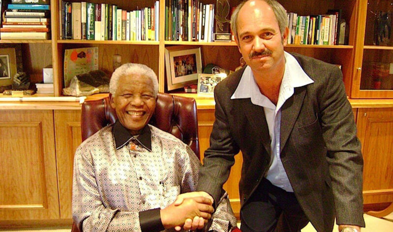 Nelson mandela shaking hands with a man.
