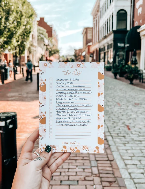 A person holding up a card with a list of things to do in a city.