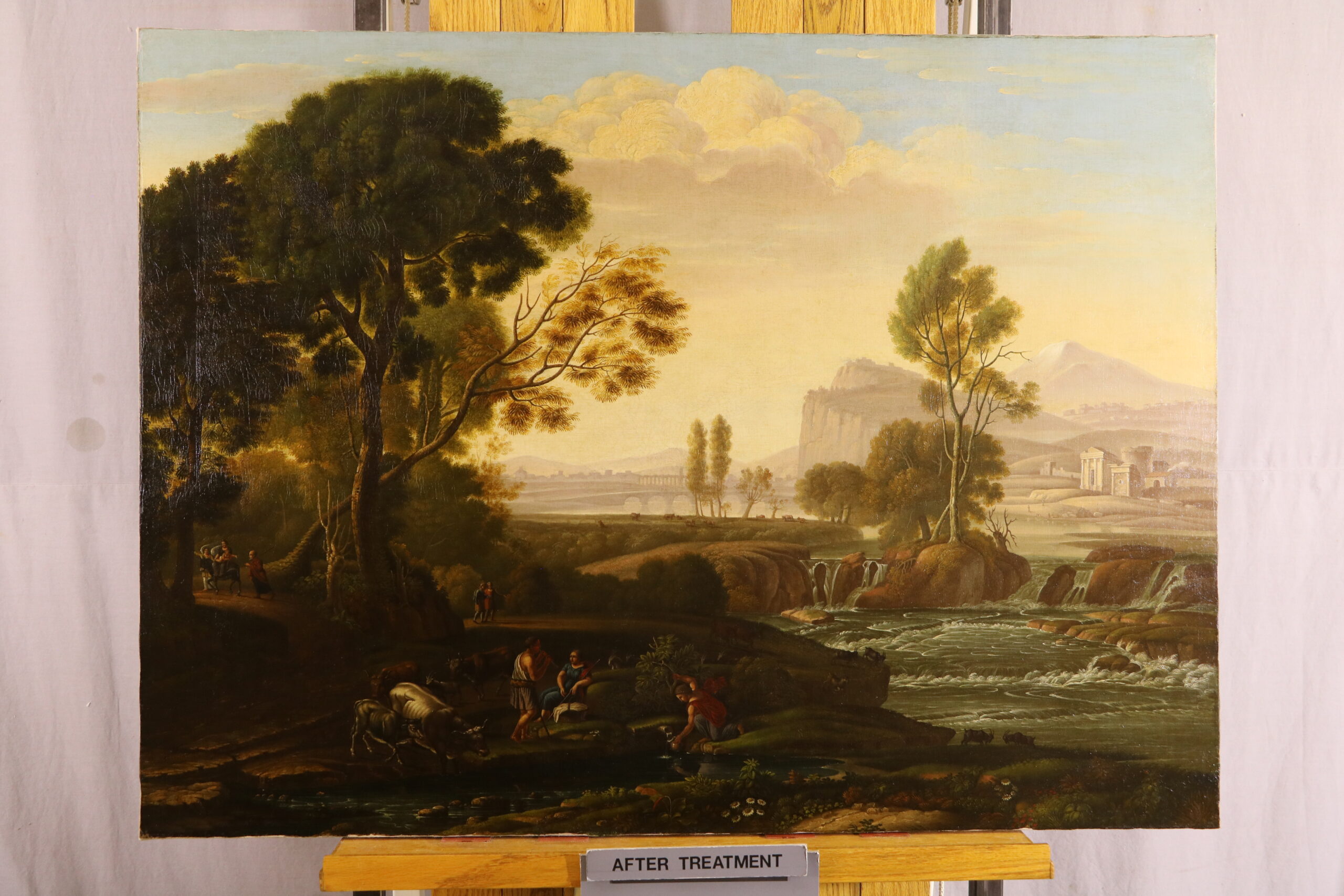 A painting on a easel. The painting is of Egypt and has trees