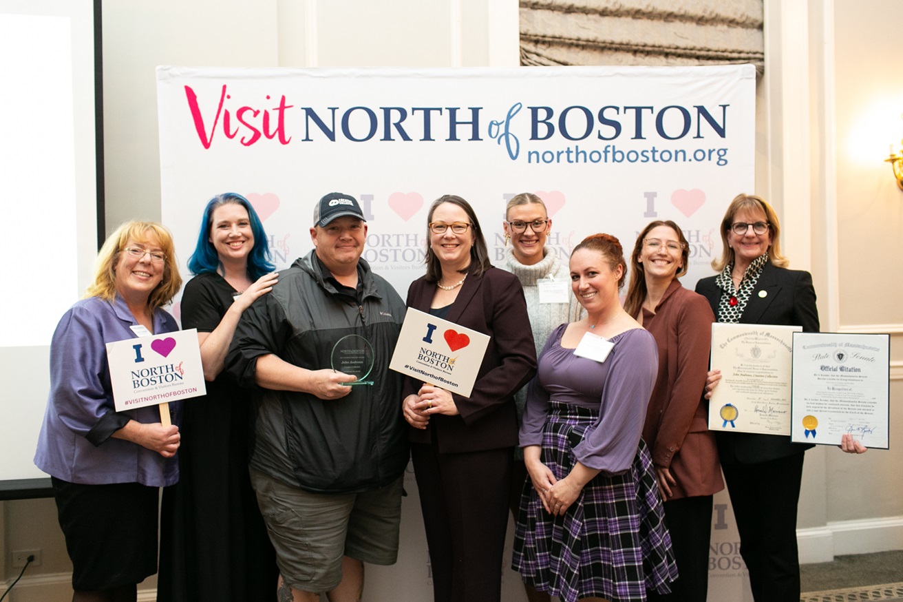 A group of people standing in front of a sign that says visit north boston.