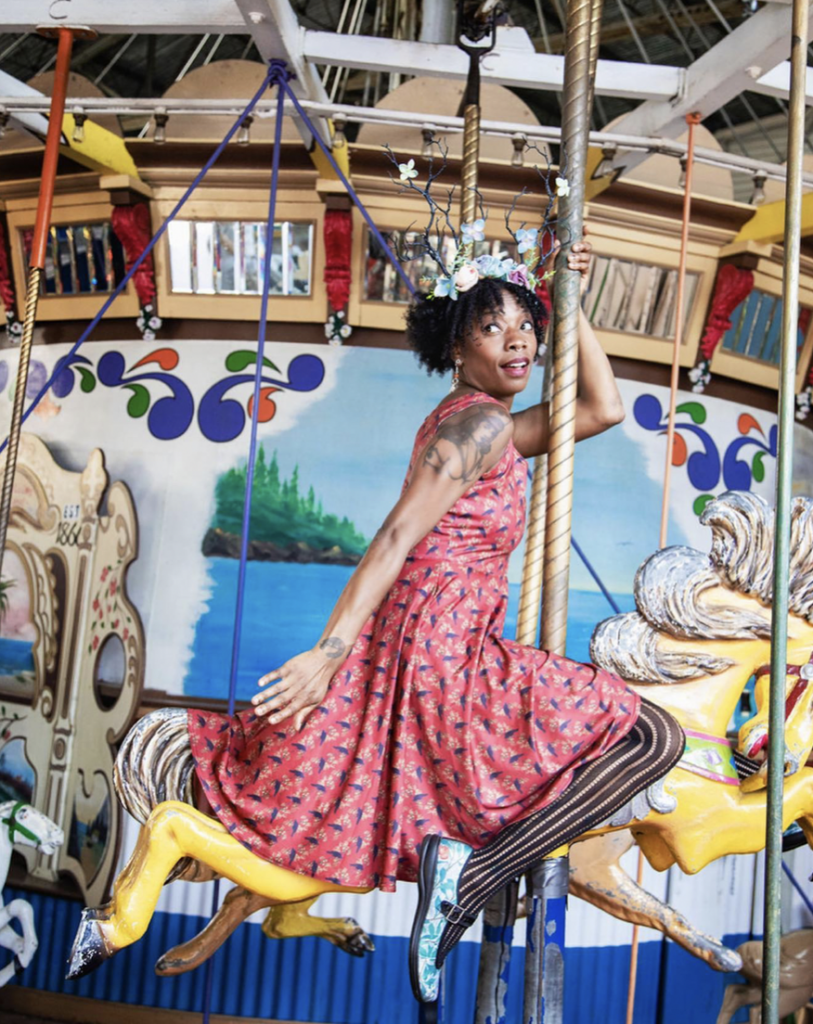 A woman wearing a dress on a carousel during Small Business Saturday.