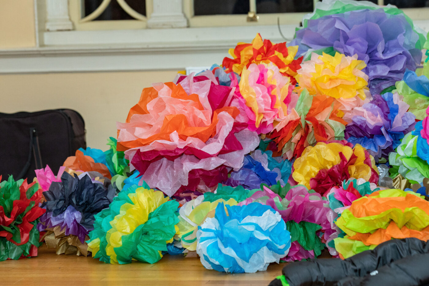 A vibrant array of paper flowers, artfully arranged on a wooden surface.