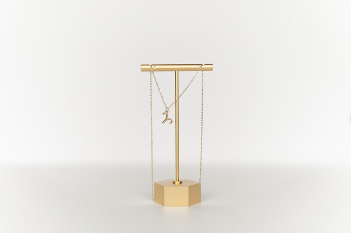 Experience the allure of a gold jewelry stand, elegantly showcasing two stunning necklaces. This aesthetic gold piece not only enhances your precious trinkets but also elevates your home's decor. Ideal for necklace organization and display, this stand guarantees both functionality and luxury in one sophisticated package.