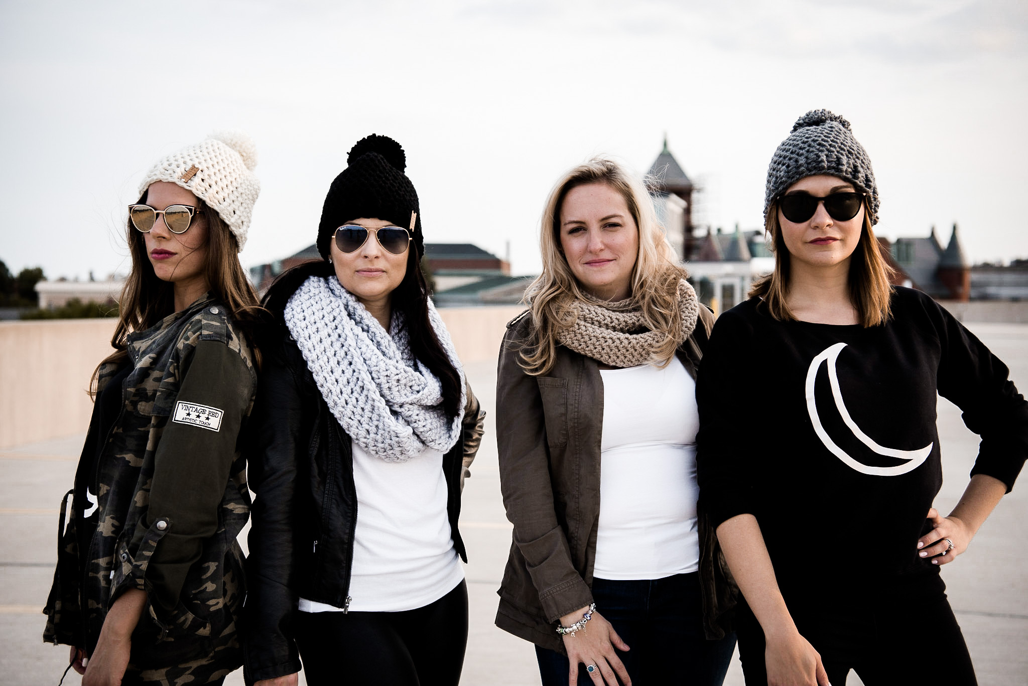 Four ladies donned in stylish hats and sunglasses, enjoying some rooftop moments.