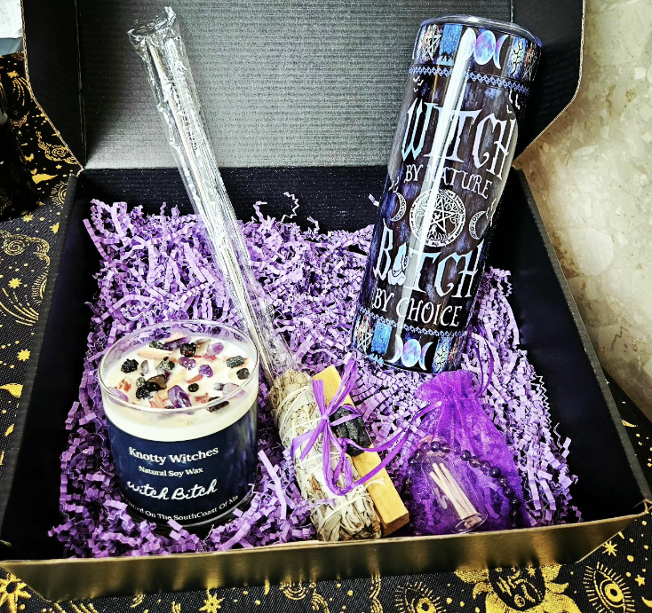 A vibrant purple package containing a candle, a candle holder, and a secondary candle for added ambiance.