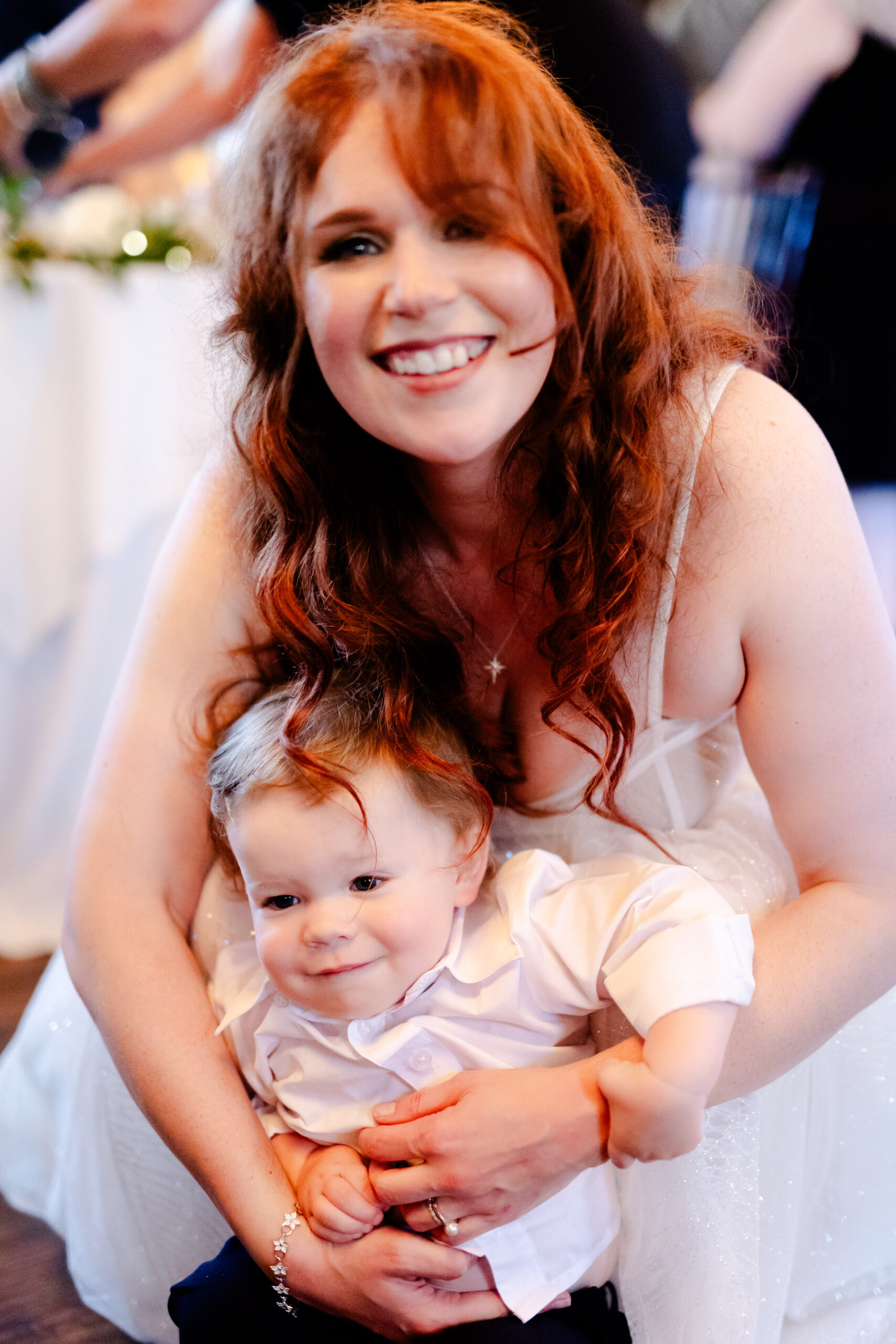 A lady cradling an infant during a marriage ceremony.