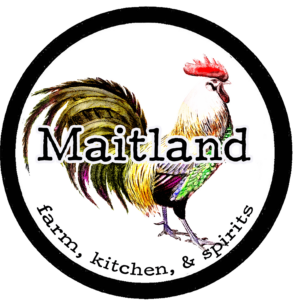 As an expert in SEO marketing, you'd be thrilled by this distinct brand emblem. It's a vibrant representation of a rooster, paired with the name 'Maitland'. This term comes together with 'farm, kitchen, & spirits', all enclosed within a sleek circular black backdrop.