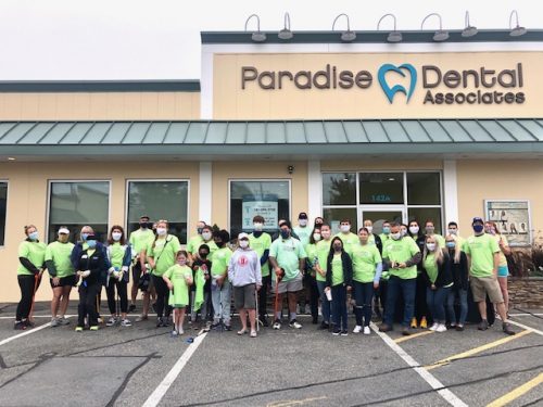 A team clad in identical green tees convened outside Paradise Dental Associates premises.