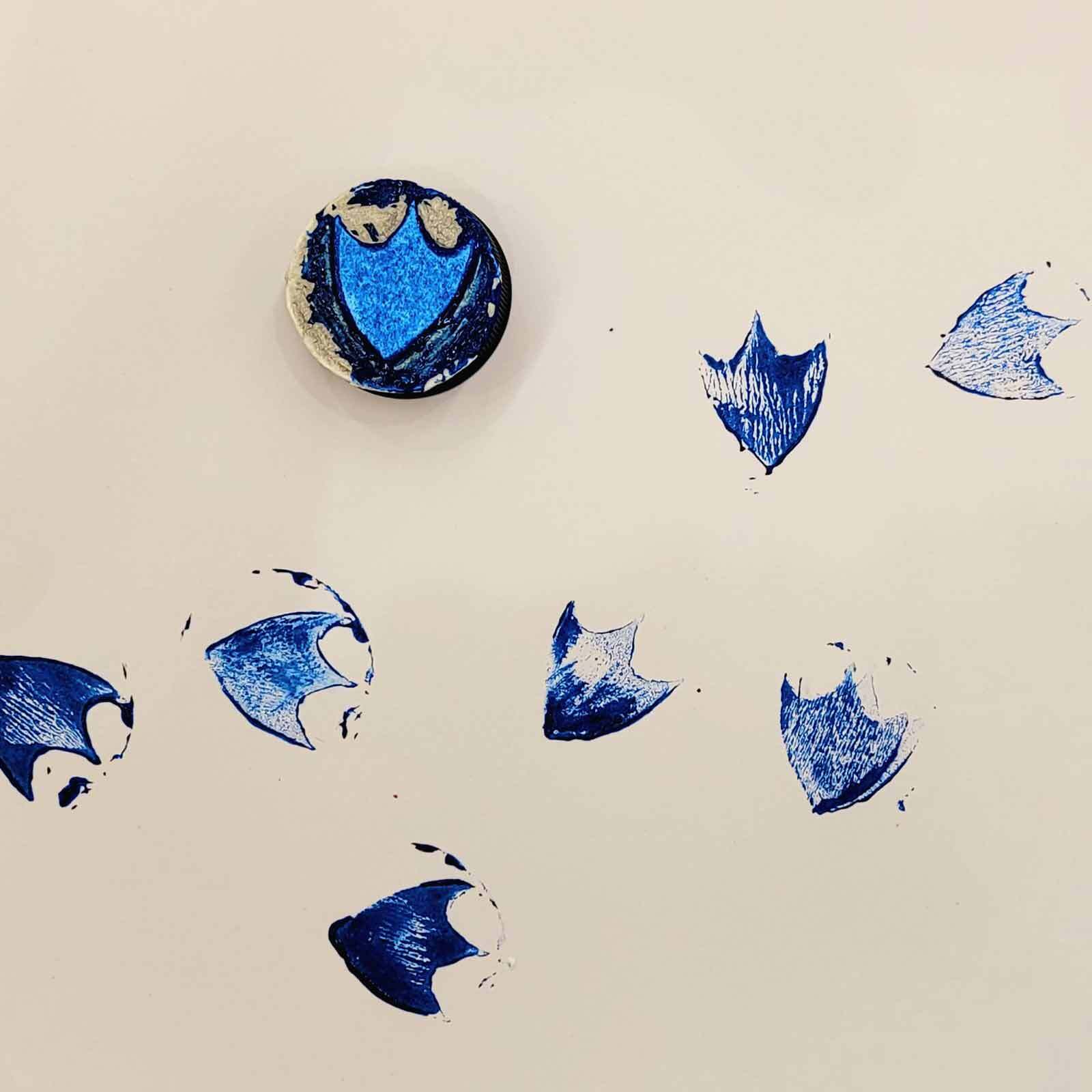 A porcelain object with a blue and white design is broken into multiple fragments against a simple backdrop.