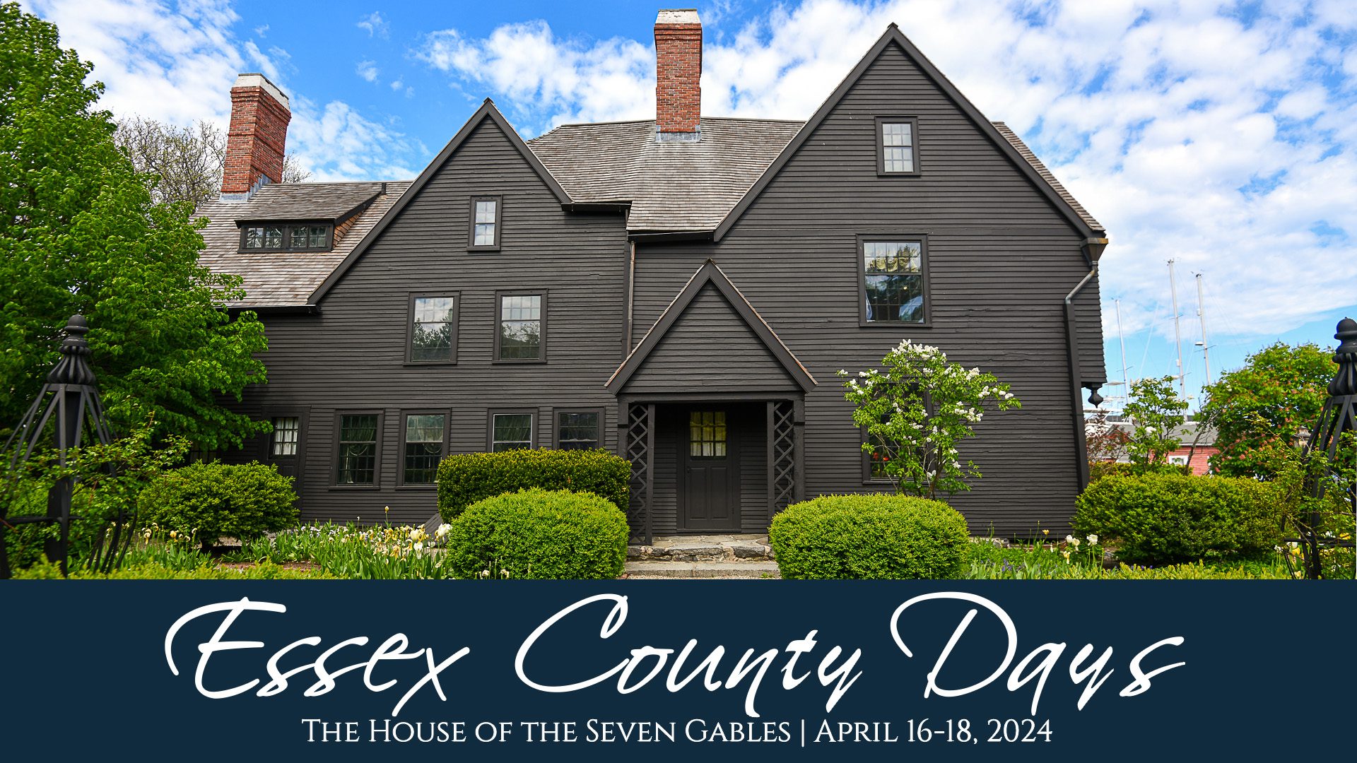 Experience the charm of a vintage wooden home with a unique dark exterior set against a beautiful blue sky. Celebrate Essex County Days at the iconic House of the Seven Gables from April 16-18, 2024.