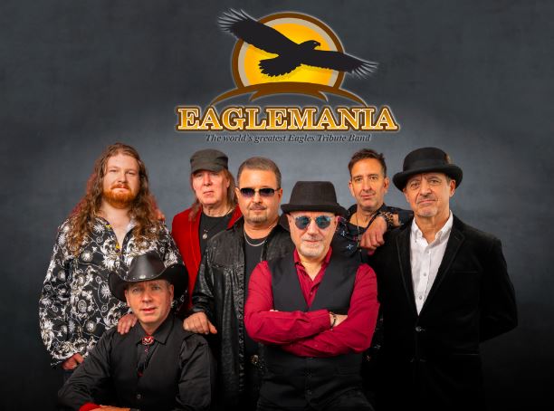 A captivating image of the seven male stars of "Eaglemania," labeled as the top Eagles tribute band, firmly posing together with their logo proudly displayed against a dark backdrop.