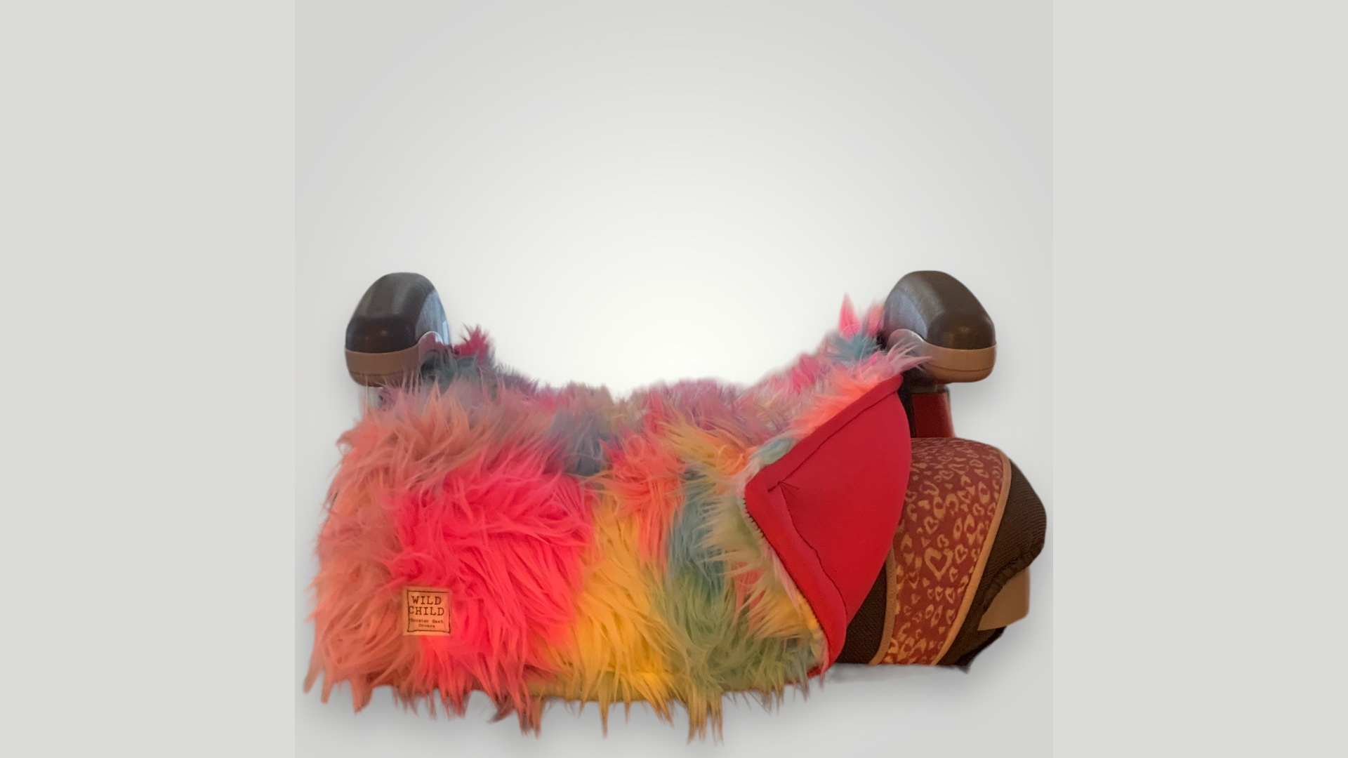 A rainbow faux fur throw, red pillow, and patterned blanket from Essex County small businesses energize this office chair with local flair.