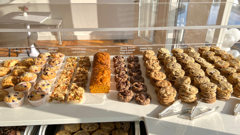 A vibrant bakery case bursts with 350 treats—muffins, pumpkin bread, cookies—uniting Essex County locals in sweet delight.